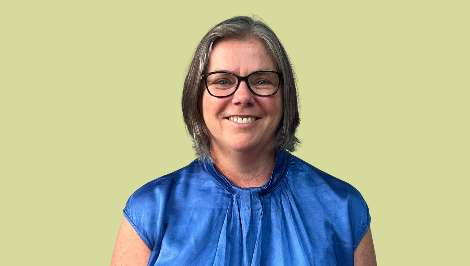 A head-and-shoulders photo of Monique Morar on a bright green background