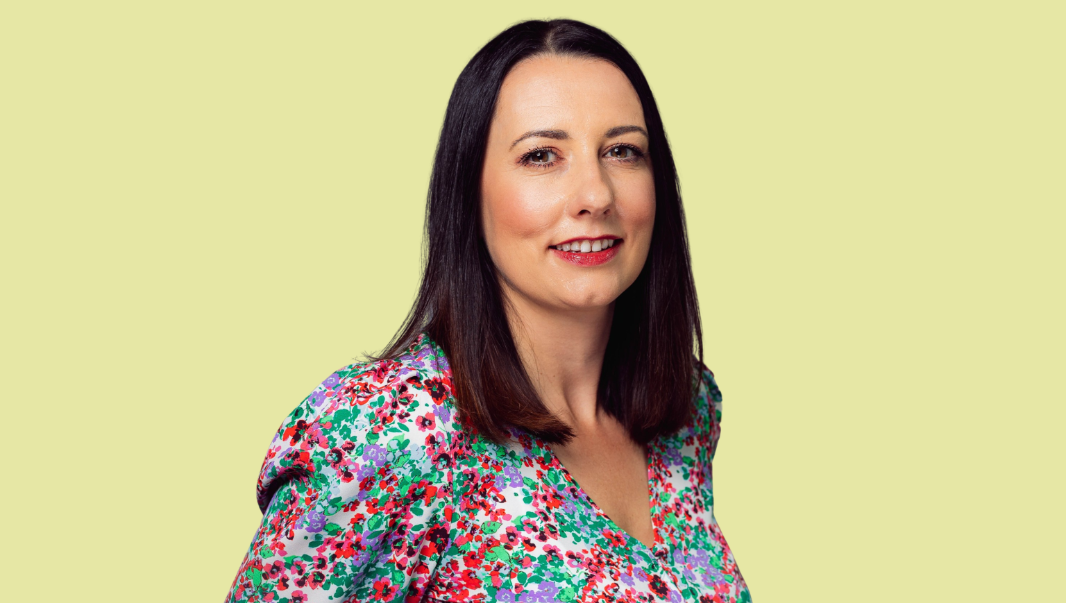 A headshot of Emma Law on a yellow-green background